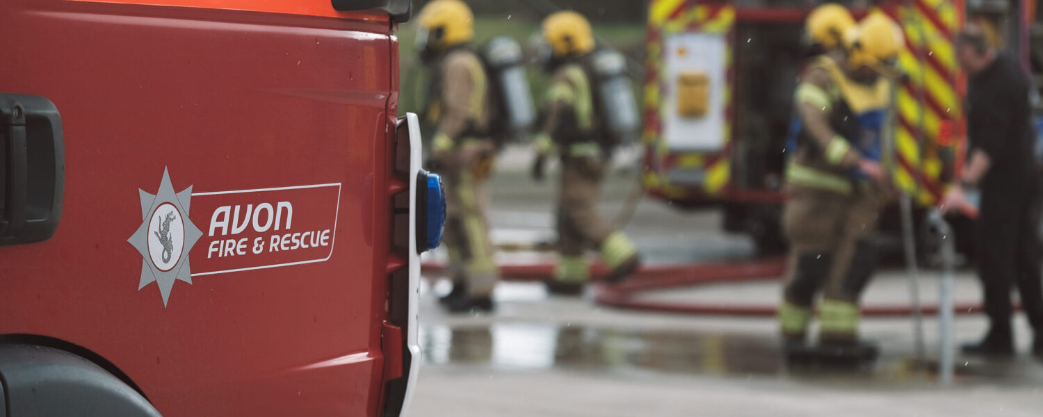 Fire engine in the front with firefighters working in the background